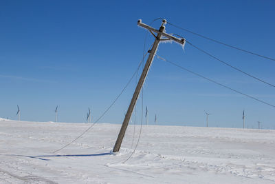 Leaning power pole with downed lines.