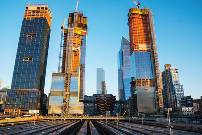 Low angle view of skyscrapers against blue sky