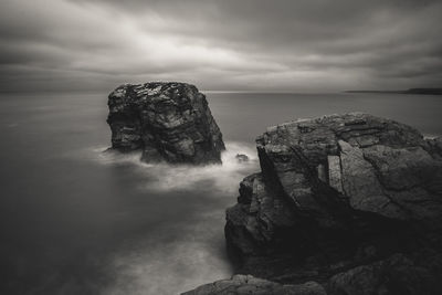 Rock formations by sea against sky