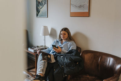 Female patient using cell phone in waiting room