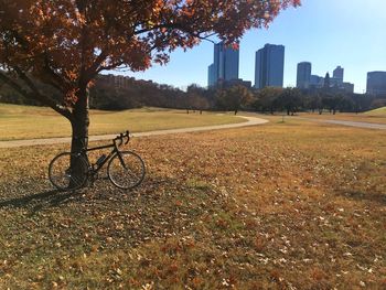 Bicycle on field by city during autumn