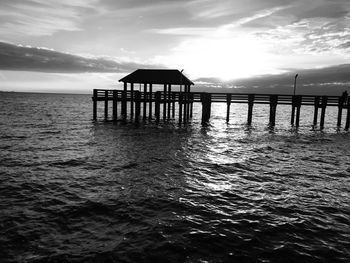 Silhouette pier on sea against sky