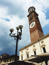 Low angle view of clock tower against cloudy sky