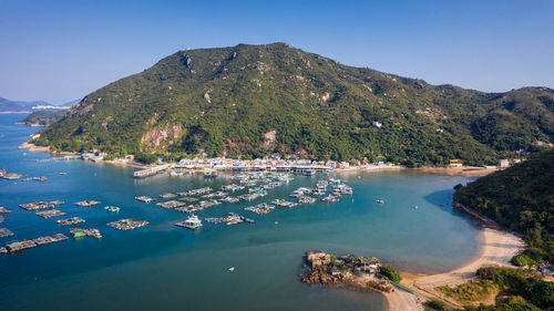 Scenic view of lake and mountains against clear blue sky