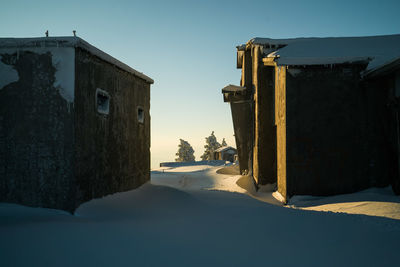 Abandoned building against clear sky during winter