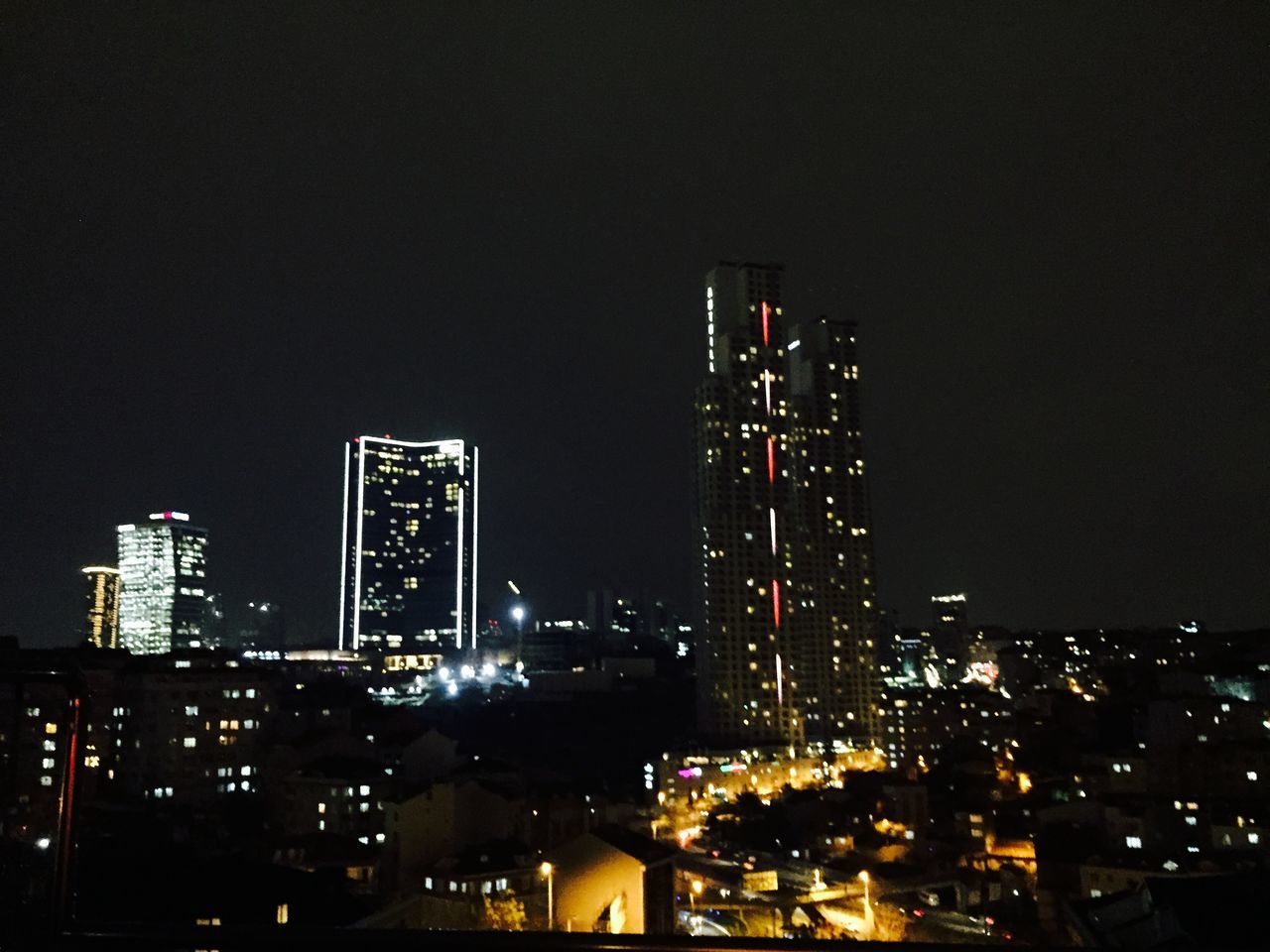 illuminated, night, city, building exterior, architecture, cityscape, skyscraper, built structure, tall - high, modern, urban skyline, tower, office building, city life, copy space, development, clear sky, sky, capital cities, financial district