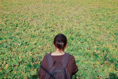 Rear view of woman standing on field