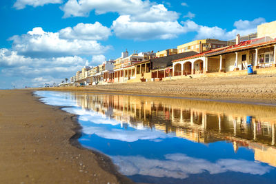 Panoramic view of beach and buildings against sky