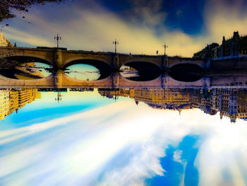 View of bridge over river against cloudy sky