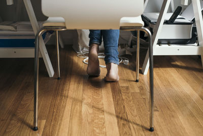 Low section of fashion designer sitting on chair at home