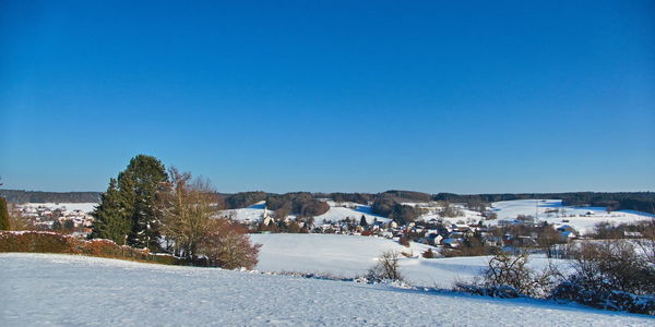 Scenic view of winter against clear blue sky