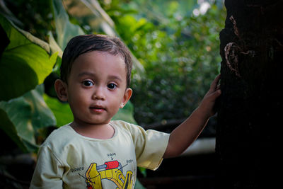 Portrait of cute boy looking away outdoors