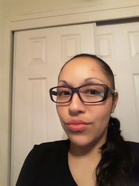 Portrait of young woman wearing eyeglasses at home