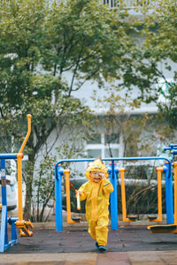 Full length of girl standing by yellow tree