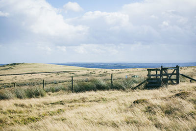 Fence on field against sky