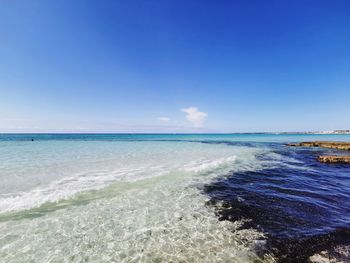 Scenic view of beach against blue sky