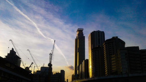 Low angle view of buildings against cloudy sky