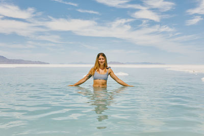 Young woman in bathing suit exploring the bonneville salt flats.