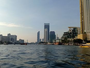 River and buildings against sky in city