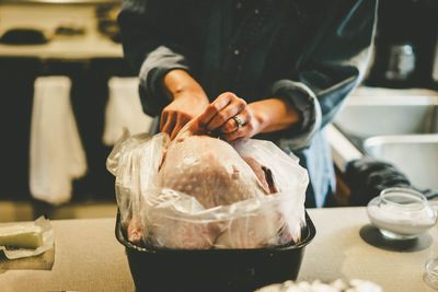 Close-up of hands preparing meat