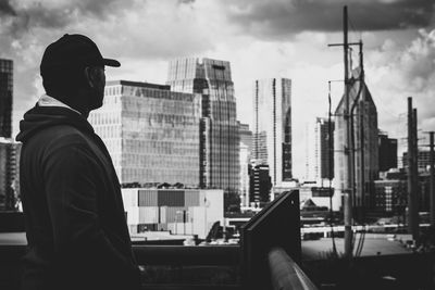 Man in city against sky