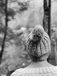 Black and white monochrome rear view of woman wearing a knit hat walking in woodlands