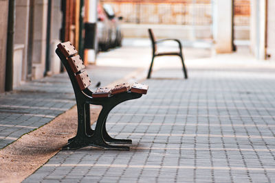 Empty bench on footpath