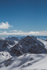 Scenic view of snowcapped mountains against blue sky