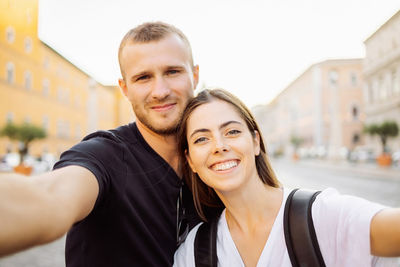 Portrait of smiling young woman standing in city