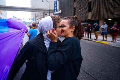 Lesbian couple kissing while standing on city street