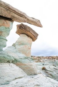 Rock formation on beach against sky