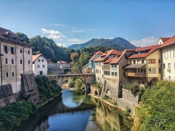 River amidst buildings in town against sky