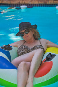 Midsection of woman sitting in swimming pool