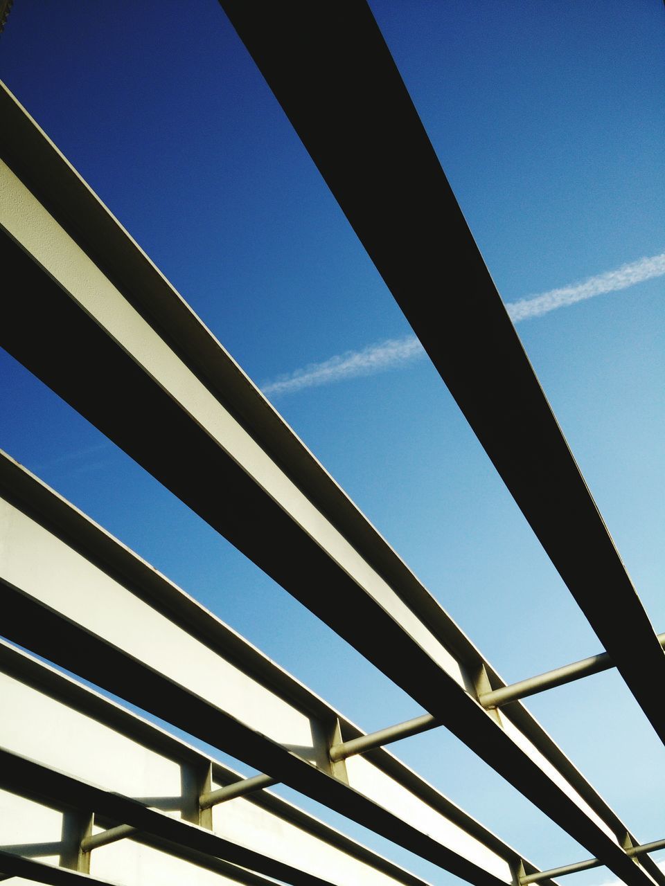 low angle view, built structure, architecture, clear sky, blue, connection, building exterior, engineering, bridge - man made structure, cable, sky, outdoors, modern, day, no people, city, power line, copy space, building, metal