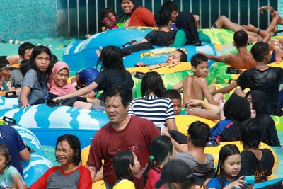 People enjoying on inflatable rafts in swimming pool