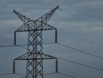 Low angle view of electricity pylon against sky