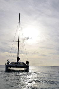 Sailboat sailing on sea against sky during sunset