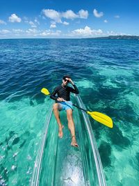 Man kayaking in sea against sky