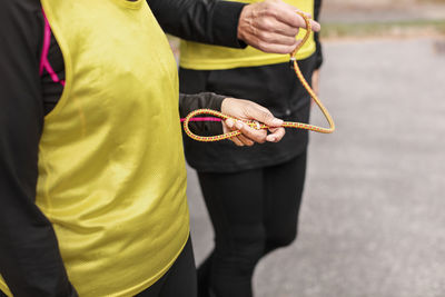 Visually impaired female triathlete running together with her guide