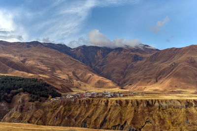 Scenic view of mountain range against cloudy sky