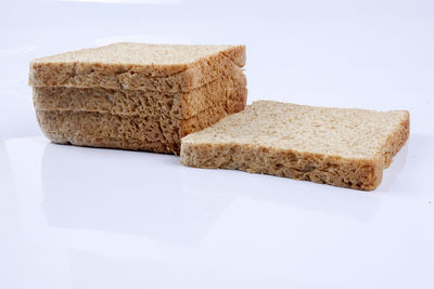 Close-up of bread in plate against white background