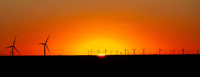 Silhouette of wind turbines at sunset