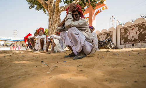 Group of people in front of built structure against sky
