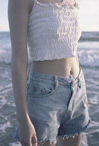 Midsection of woman standing on beach