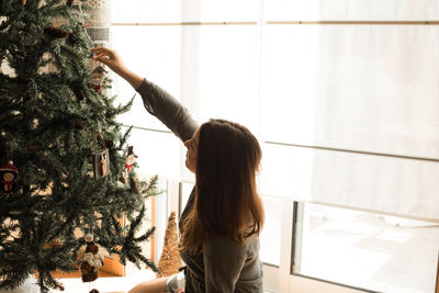 Rear view of woman standing by tree