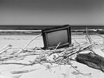 Television set on beach against sky