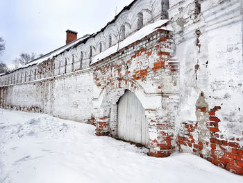 Snow on built structure against sky during winter