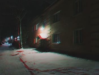 Illuminated street light on road in city at night