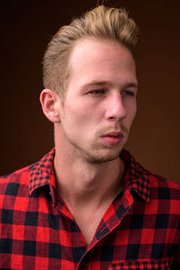 Portrait of young man against black background