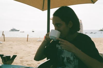 Young woman drinking water from coffee cup